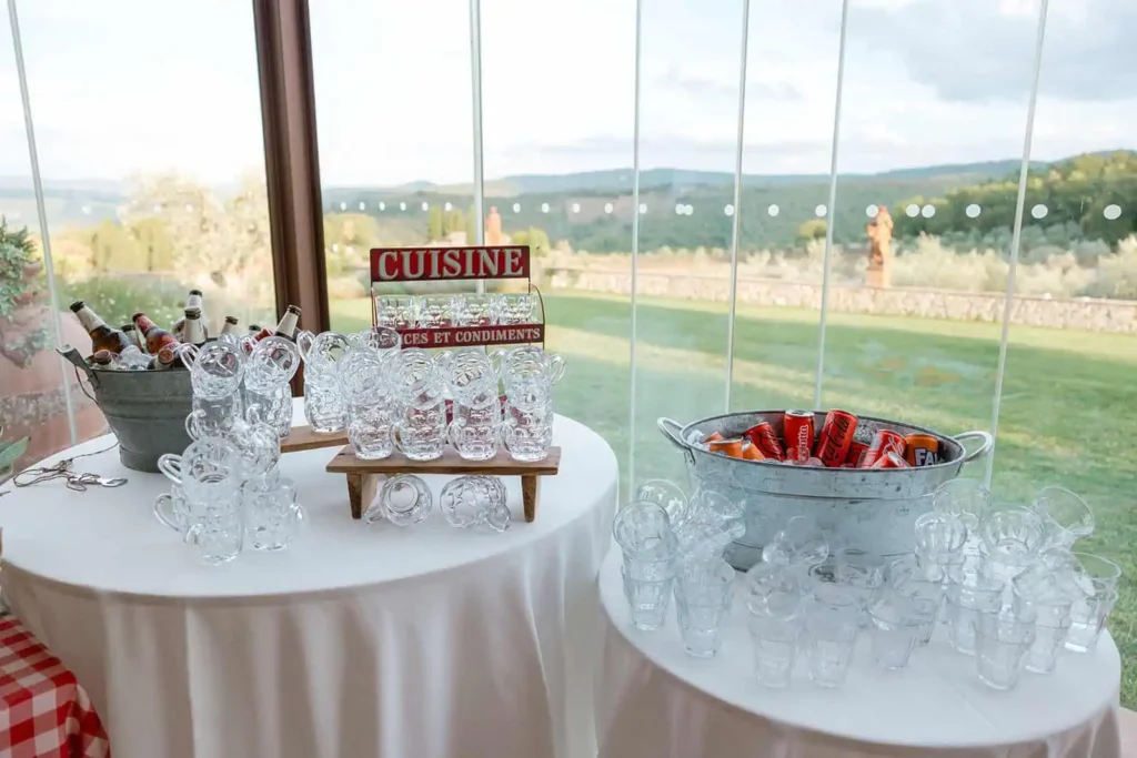 Peroni Beer bottles in ice-cold basketball with beer mugs ready to be filled. Cans of Cocacola and Fanta in the ice basket